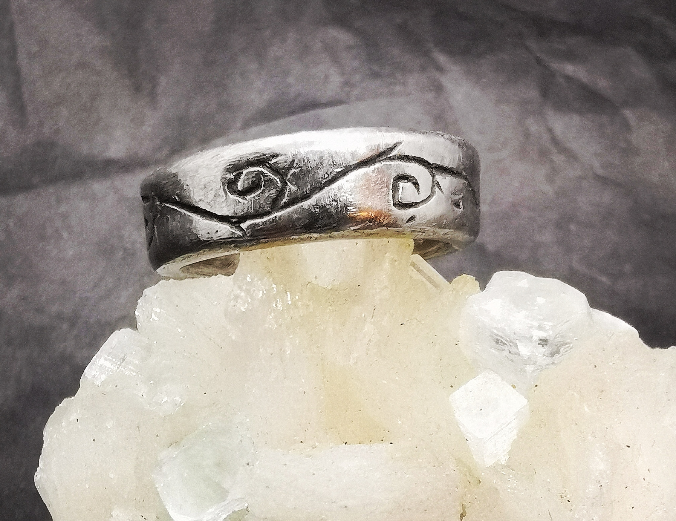 Der Ring aus Stahl ziert durch ins Ringband geschnitzte, leicht geschwärzte Ranken.